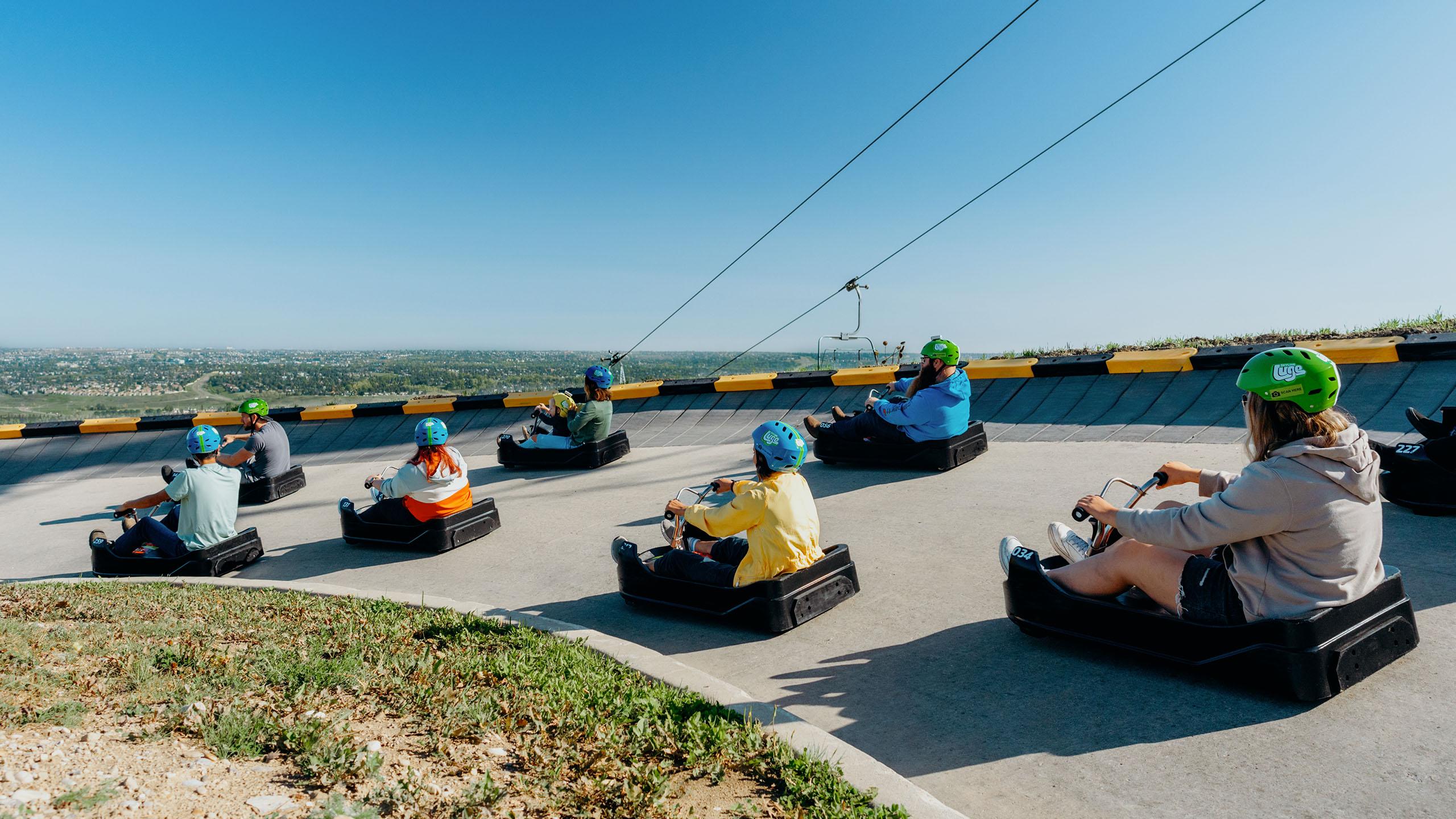A group of people ride around a corner at Downhill Karting Calgary.