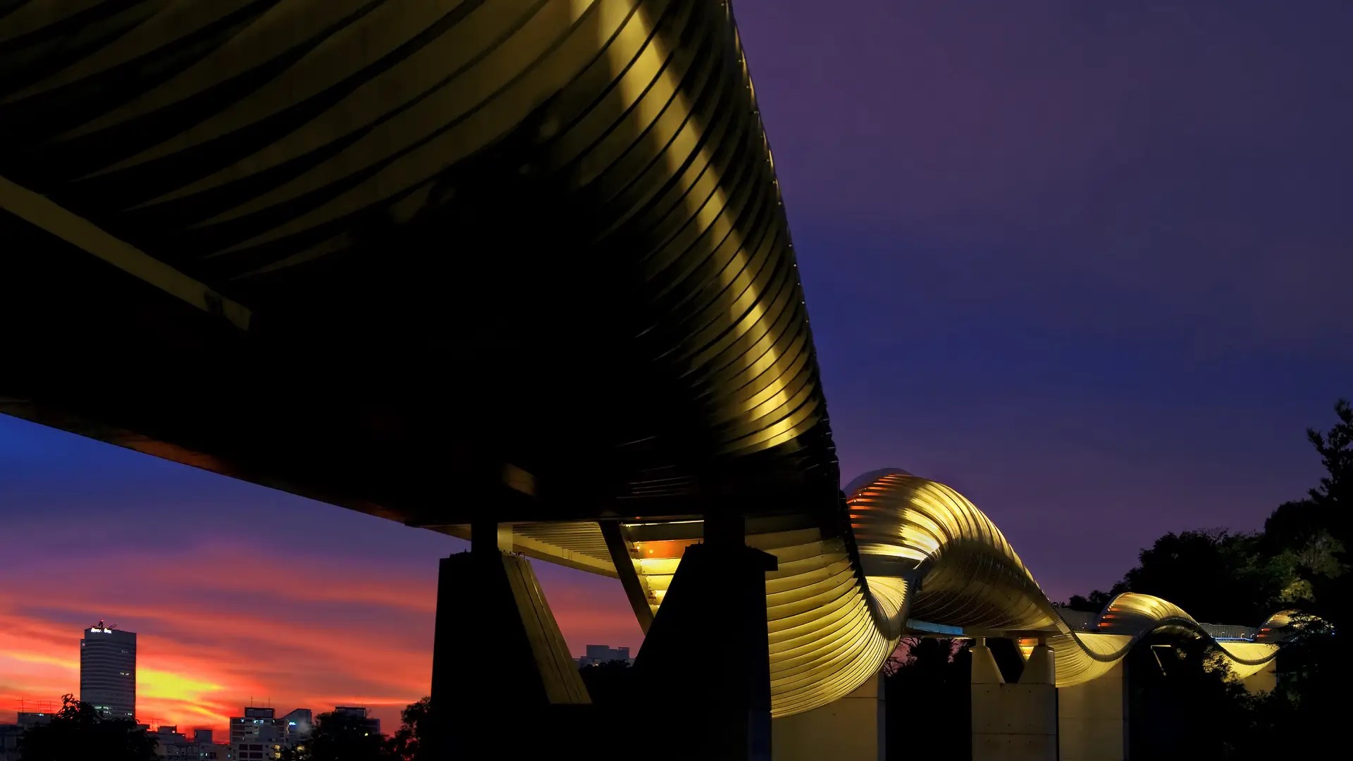 Henderson Waves pedestrian bridge illuminated with soft night lights in Singapore.