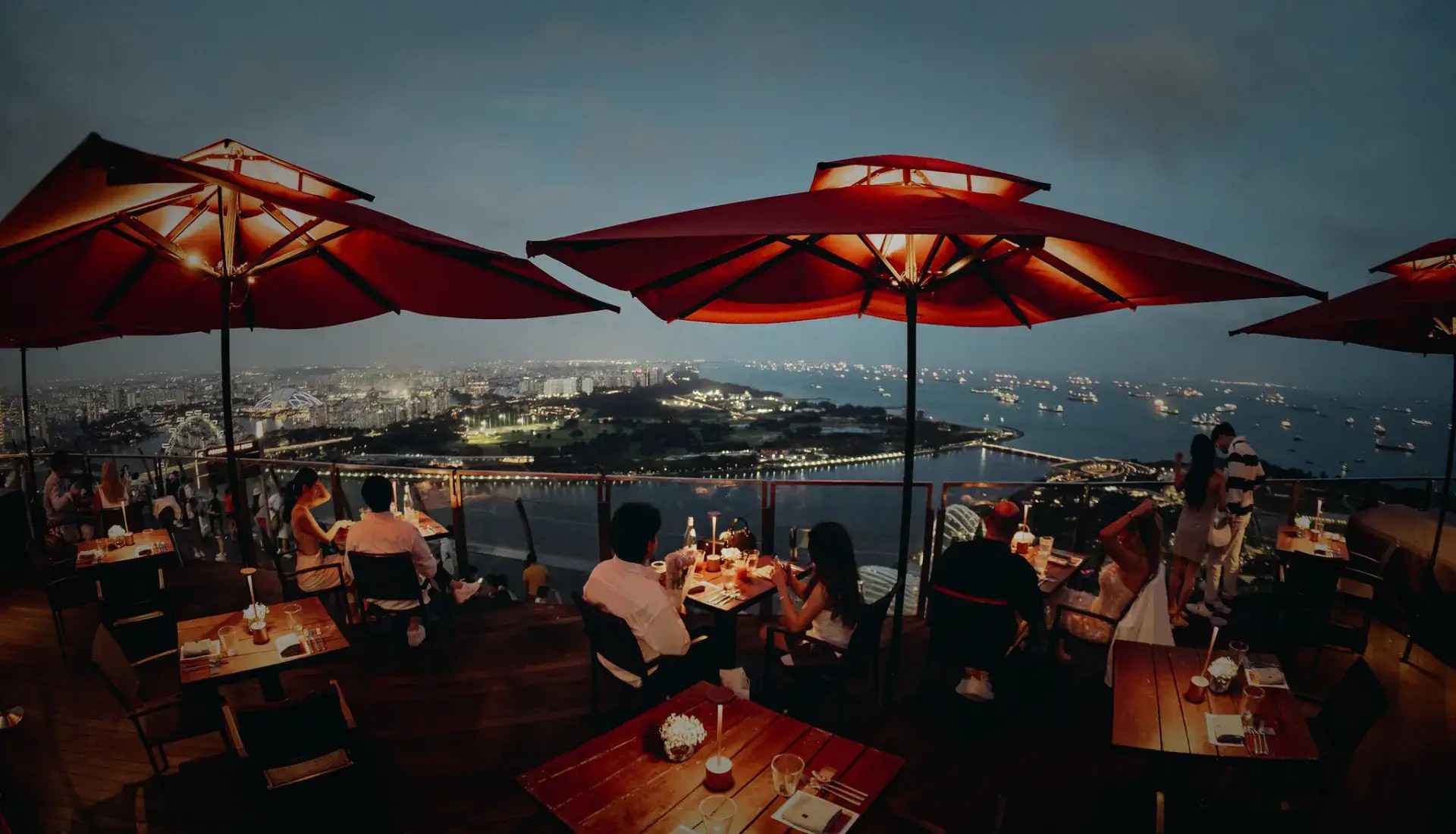 Rooftop view from CÉ LA VI at Marina Bay Sands overlooking Singapore skyline at dusk.