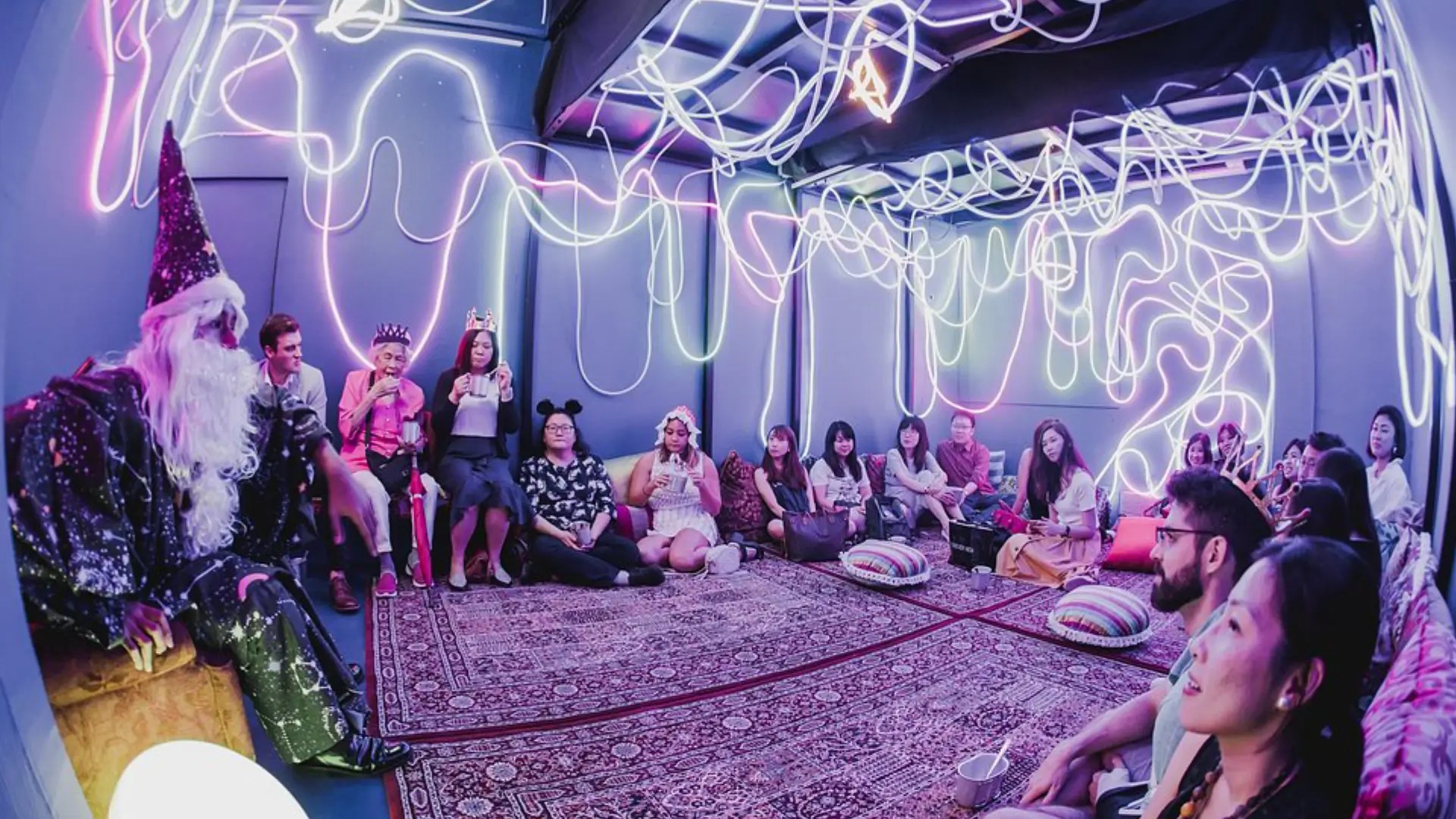 Guests seated in a neon-lit immersive theatre room during AndSoForth’s “Marie & The Nutcracker” dining experience in Singapore.