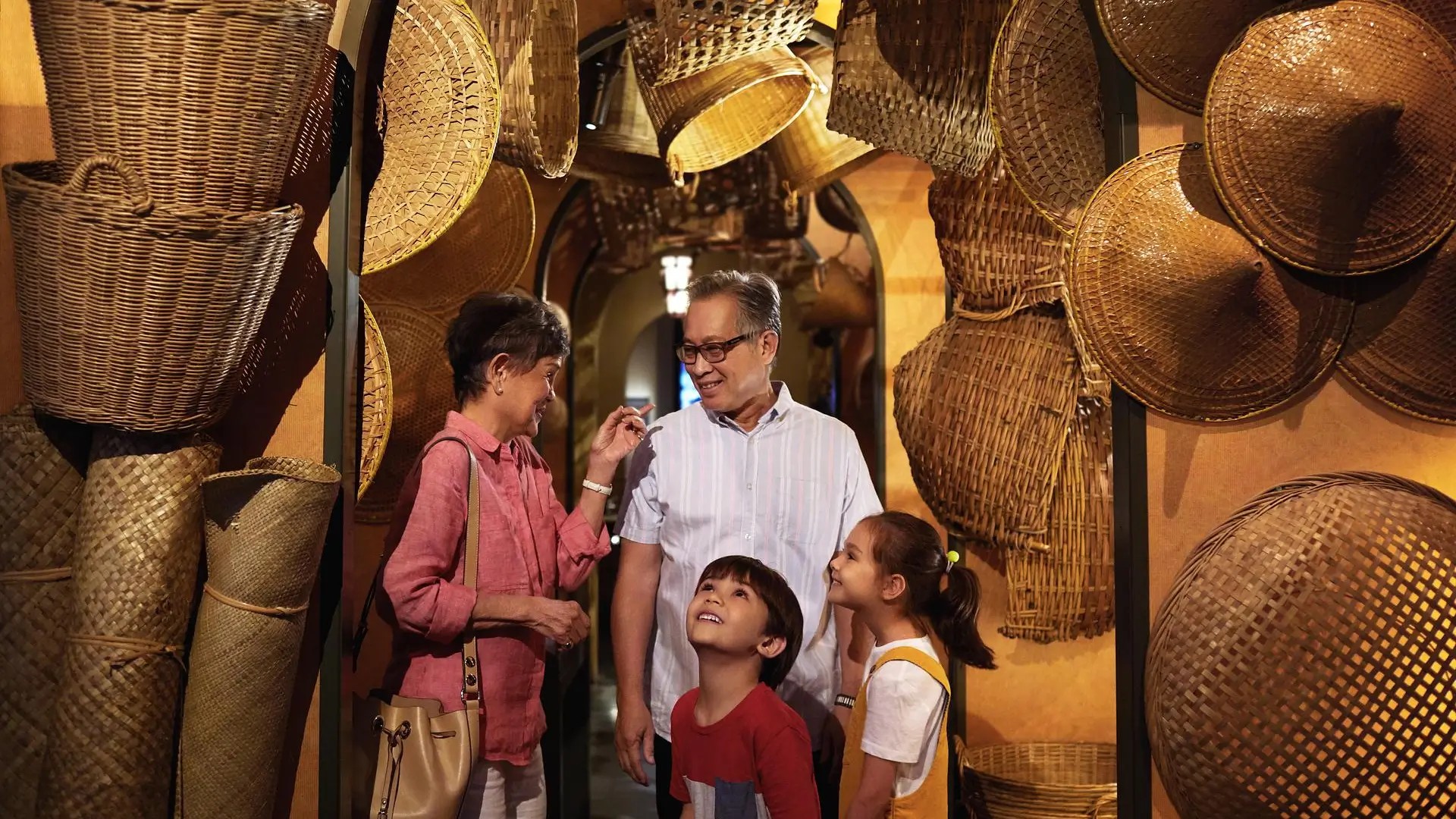 Family exploring a gallery of woven artefacts at the National Museum of Singapore.