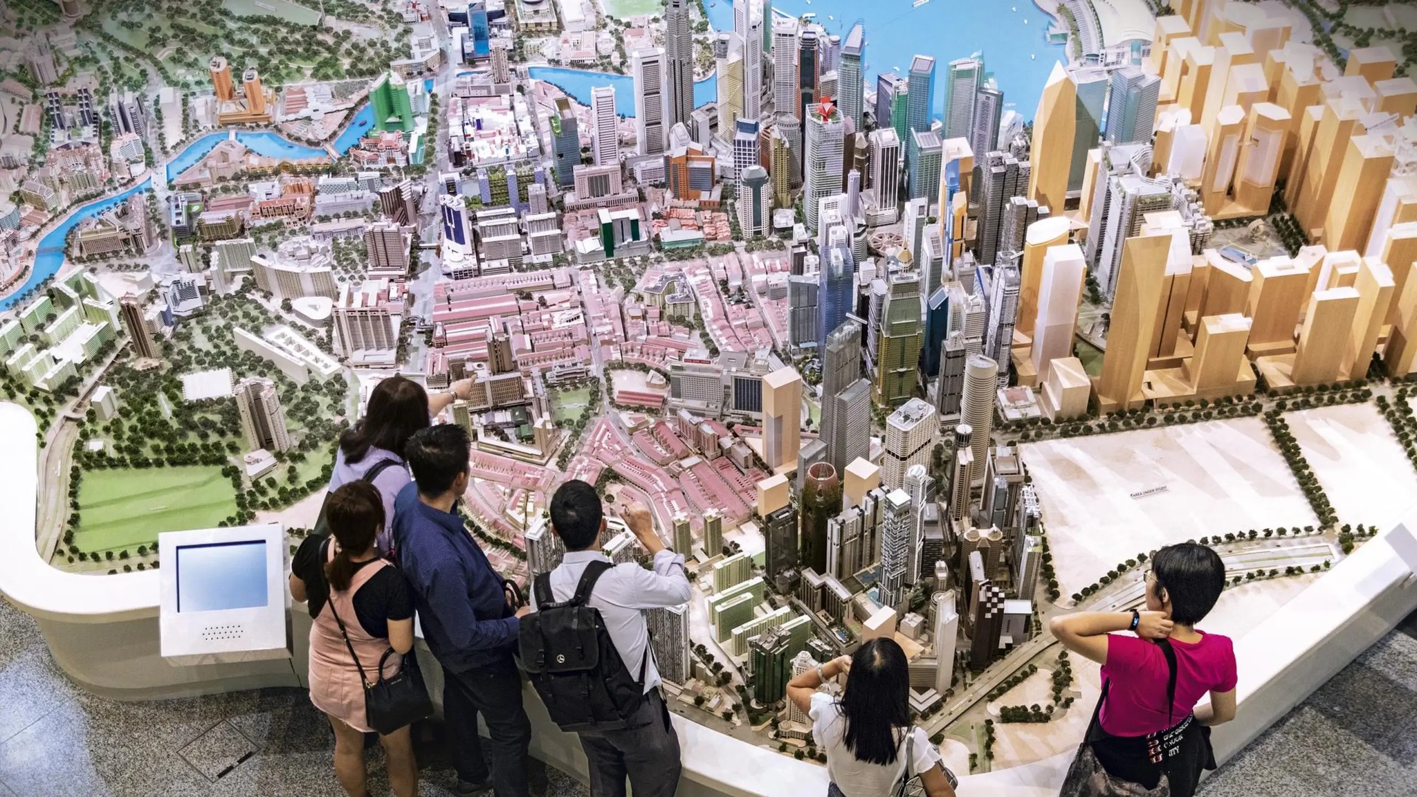 Visitors exploring a detailed scale model of Singapore’s city centre at the Singapore City Gallery.