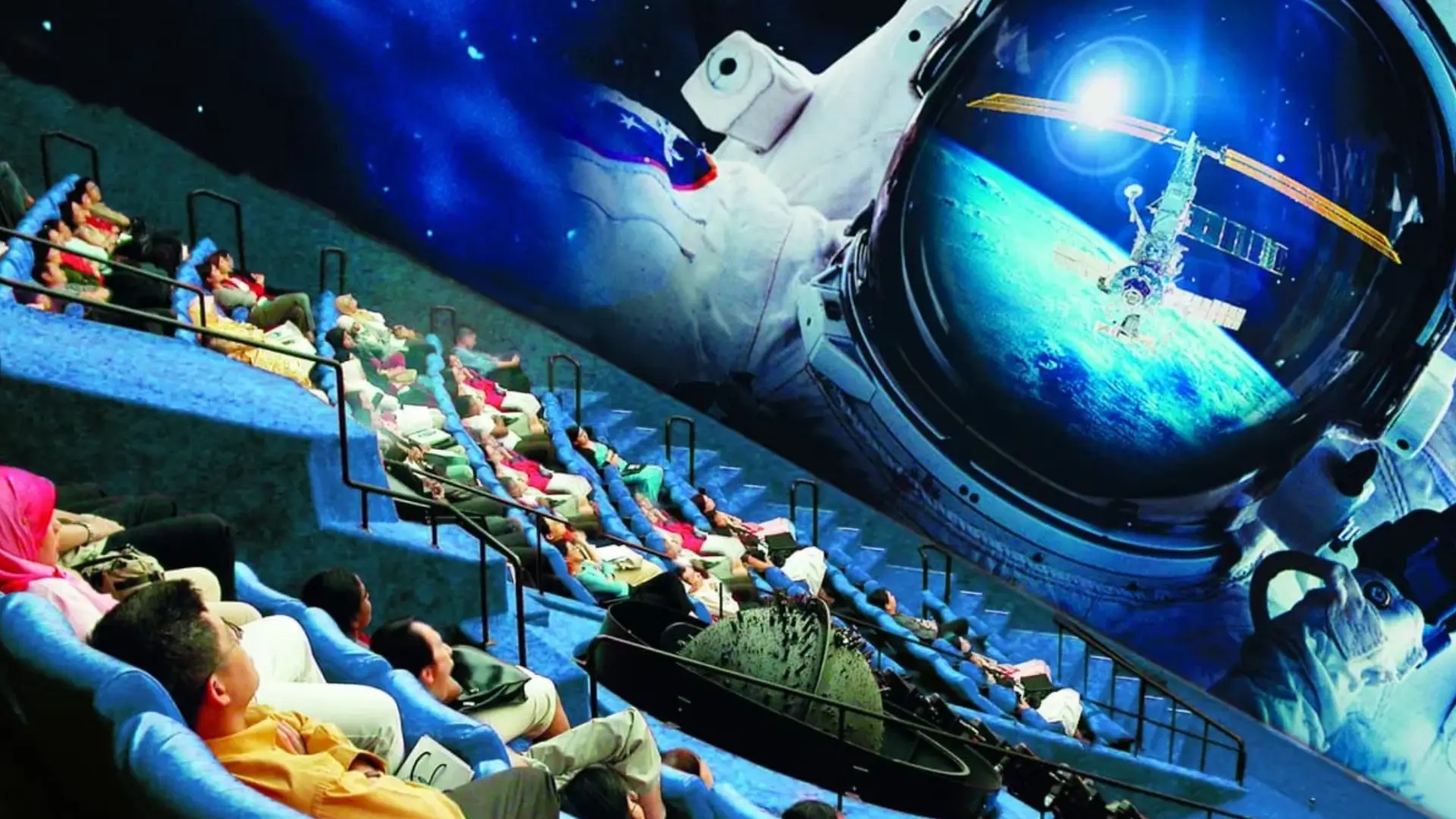Families watching an immersive space film at the Omni Theatre inside Science Centre Singapore’s domed cinema.