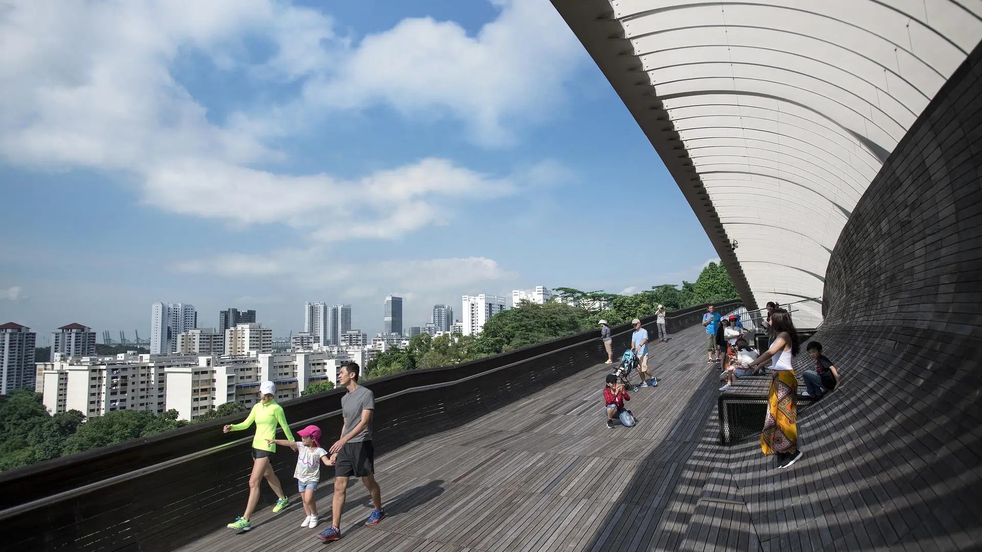 Visitors walking along Henderson Waves at the Southern Ridges, enjoying a scenic treetop walk in Singapore.