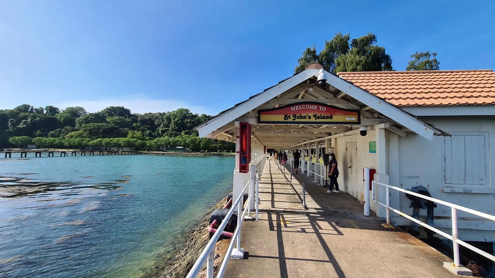 Visitors walking along the jetty at St John’s Island, Singapore, with coastal views and island greenery.