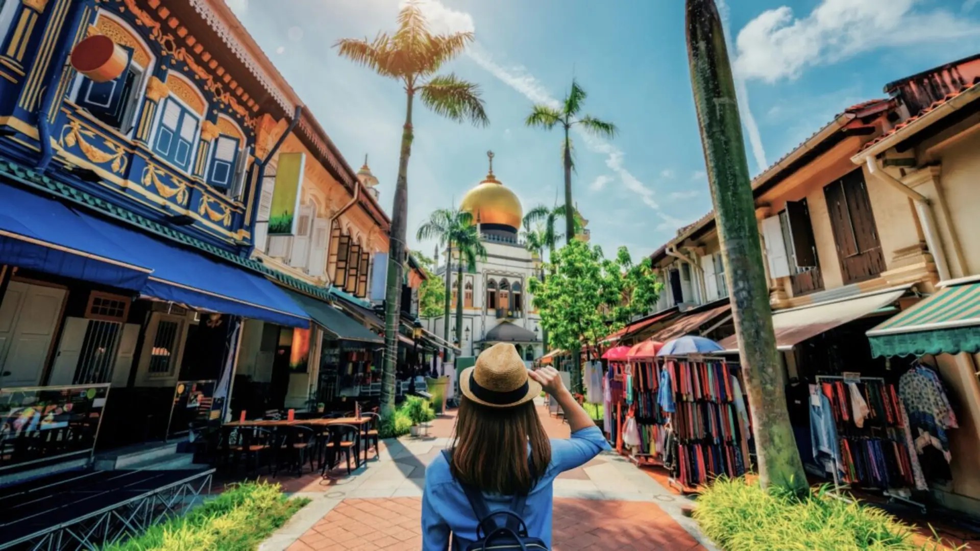 Visitor walking along Arab Street in Kampong Glam with the Sultan Mosque and colourful shophouses in Singapore.
