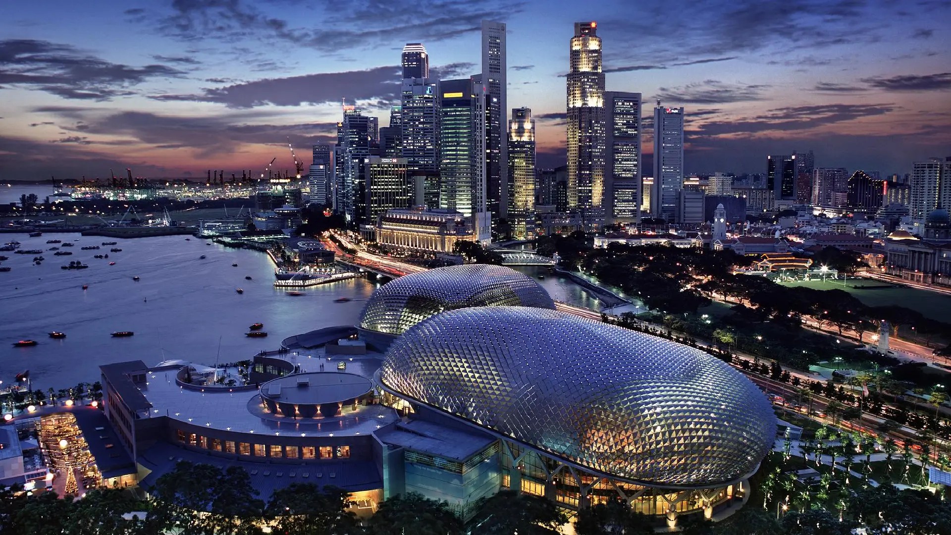 Singapore skyline at dusk with Marina Bay waterfront and Esplanade Theatres on the Bay illuminated.