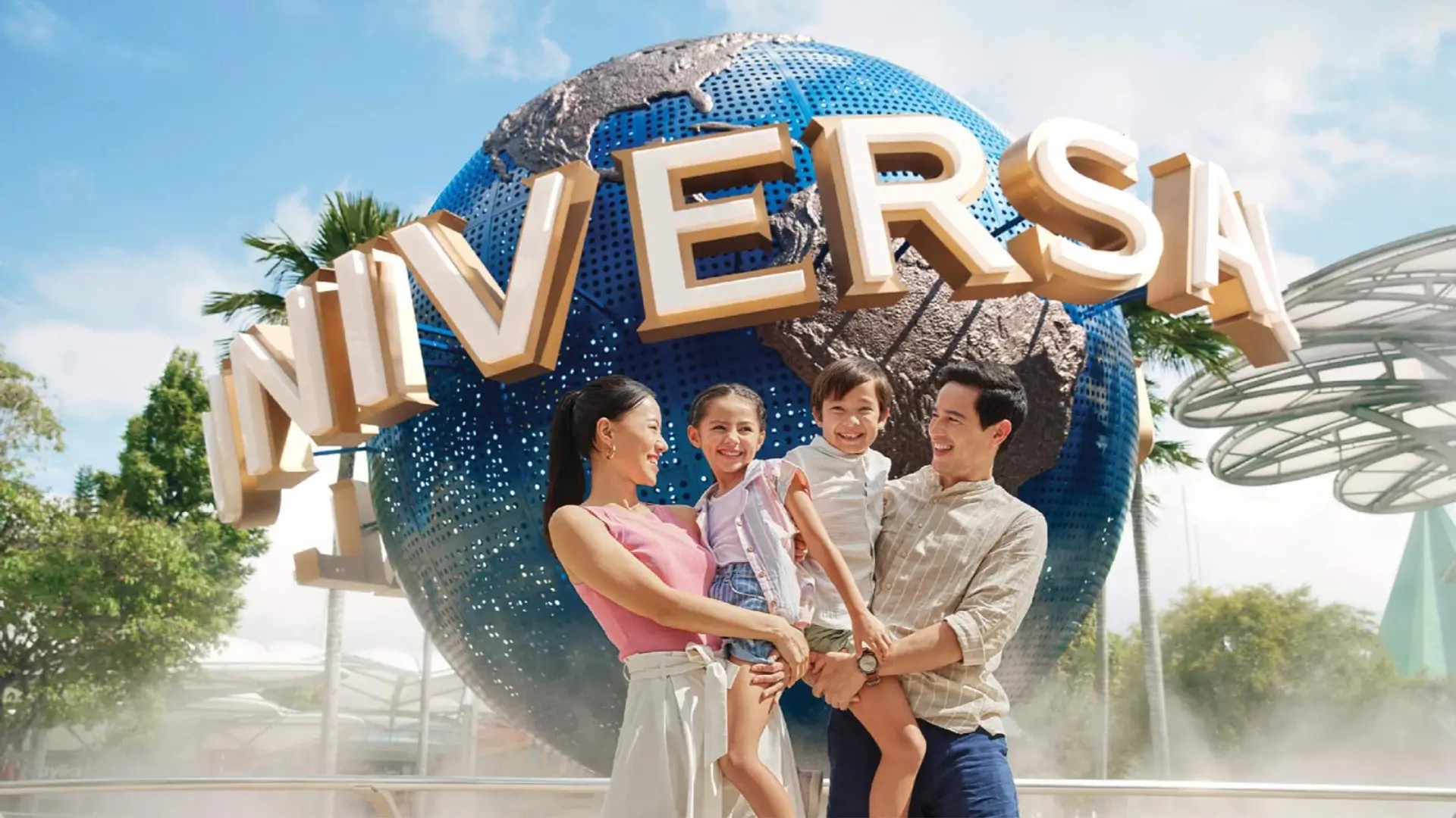 Family posing at the Universal Studios Singapore globe entrance on Sentosa Island
