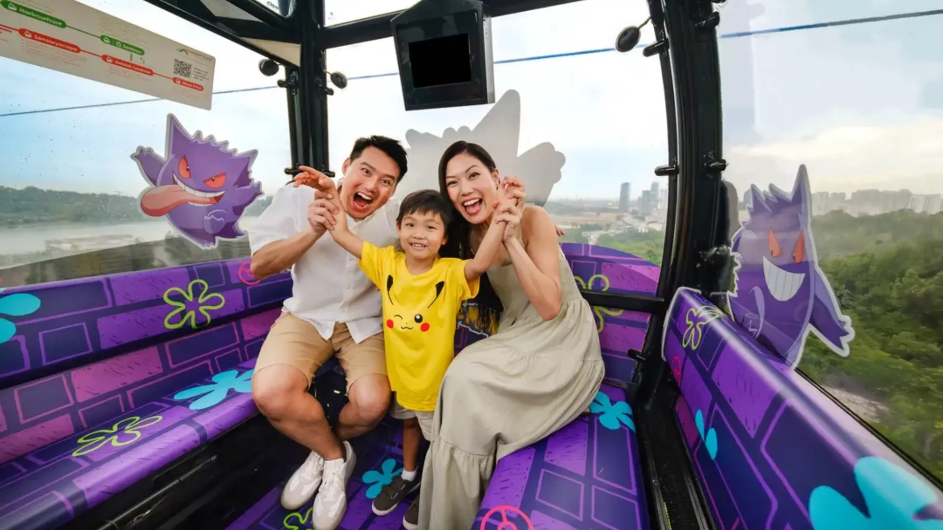 Family enjoying a ride on the Singapore Cable Car with panoramic harbour and Sentosa Island views.