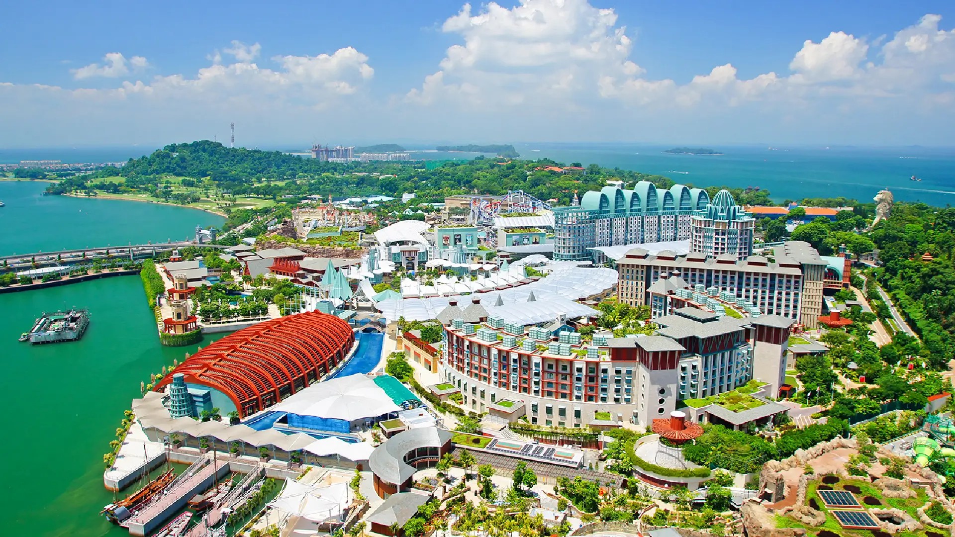 Aerial view of Sentosa Island showing resorts, attractions, waterfront areas, and tropical greenery in Singapore.