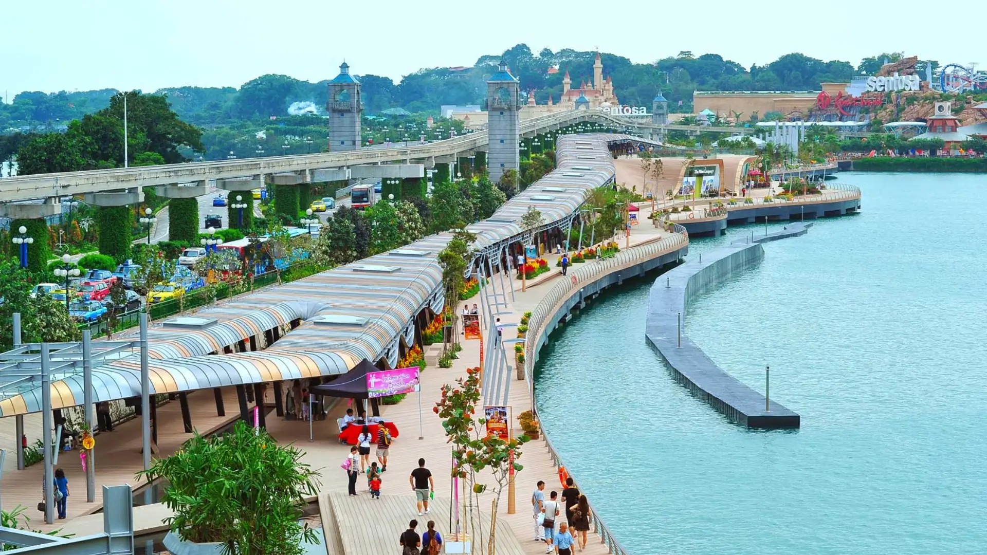 People walking along the Sentosa Boardwalk, a scenic waterfront walkway connecting VivoCity to Sentosa Island