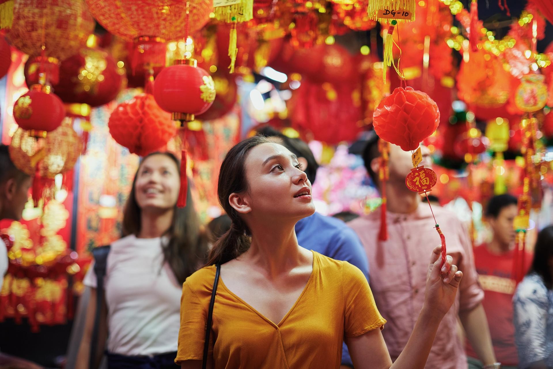Visitor exploring Singapore’s Chinatown surrounded by red lanterns and traditional street decorations