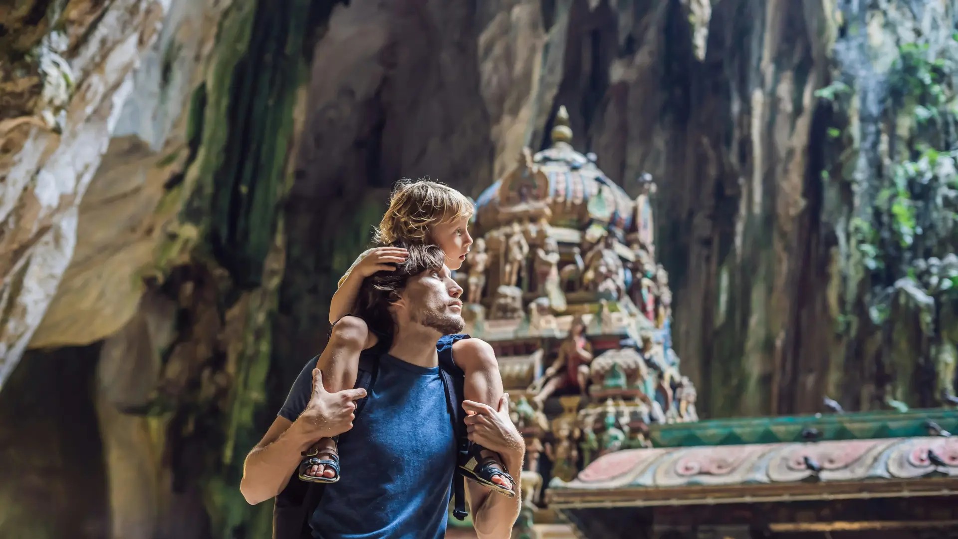 Visitor carrying a child while exploring the Batu Caves - temple complex near Kuala Lumpur, Malaysia. Photo Credit: Unsplash