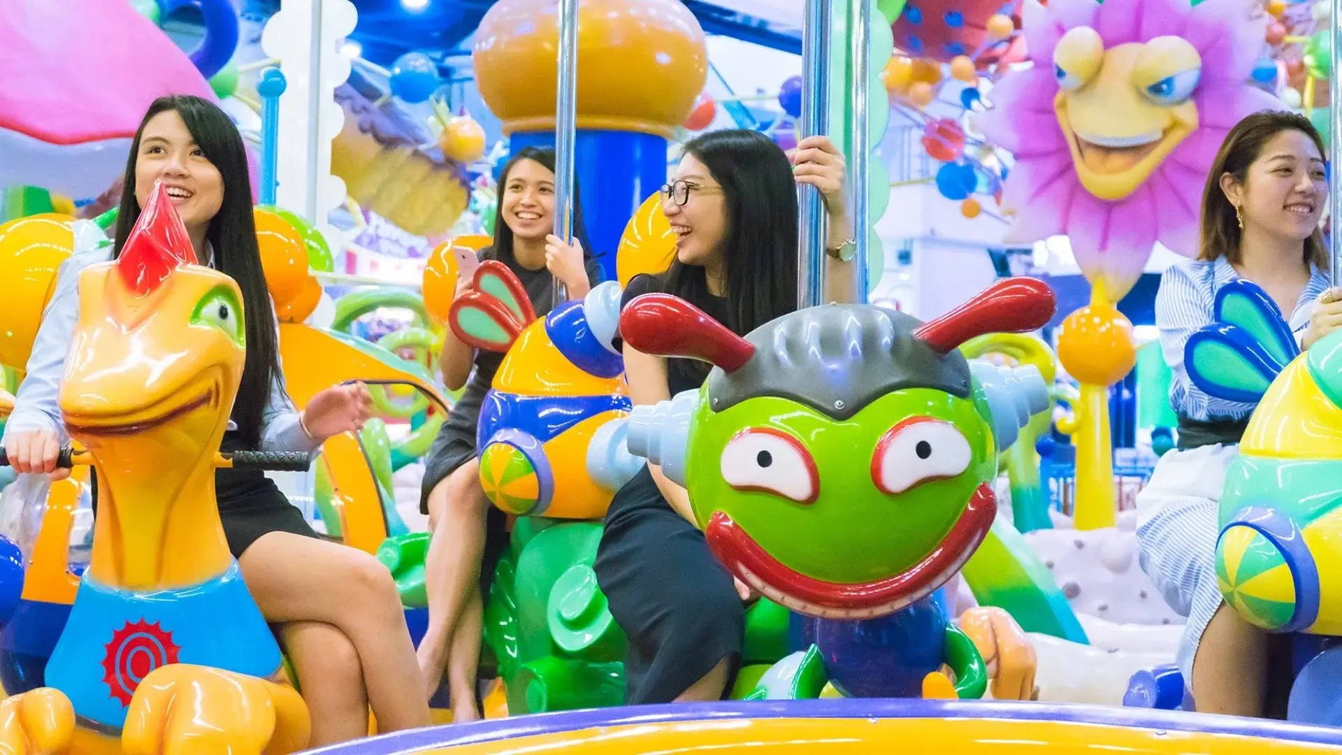 Visitors riding a colourful indoor amusement ride at Berjaya Times Square Theme Park in Kuala Lumpur