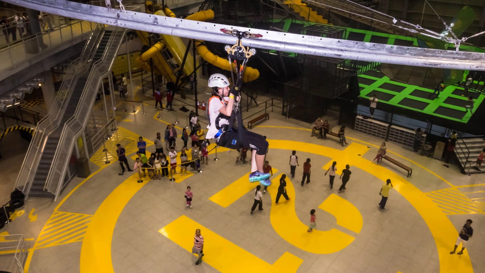Visitor riding an indoor zipline at District 21 adventure park in Kuala Lumpur